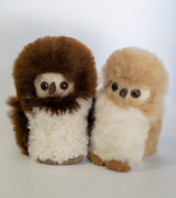Two alpaca plush toys resembling penguins with brown, white, and black fur on a white background