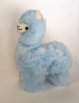 A handmade baby blue alpaca stuffed toy with a soft and fluffy texture, standing upright.