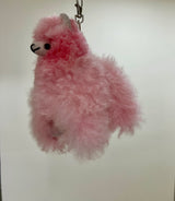 Pink fluffy keychain llama on a white background