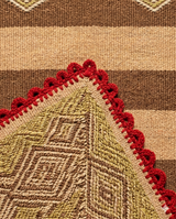 Close-up study of the hand-finished red picot scalloped edge on Archival Textile No. 103, highlighting the artisanal mineral-pigmented wool.