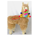 Handmade 4-foot alpaca llama in natural undyed beige, decorated with hand-tufted pompoms and earrings, made by artisans in Peru