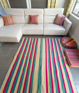 Vintage Peruvian Frazada rug No. 114 styled in modern living room showing classic vertical stripe pattern in natural cream wheat teal and fuchsia with scalloped teal whipstitch edge, 59 by 57 inches, sold one of a kind Andean textile