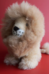 Side view of 12 inch light brown alpaca fur lion with a fluffy natural mane and glass eyes